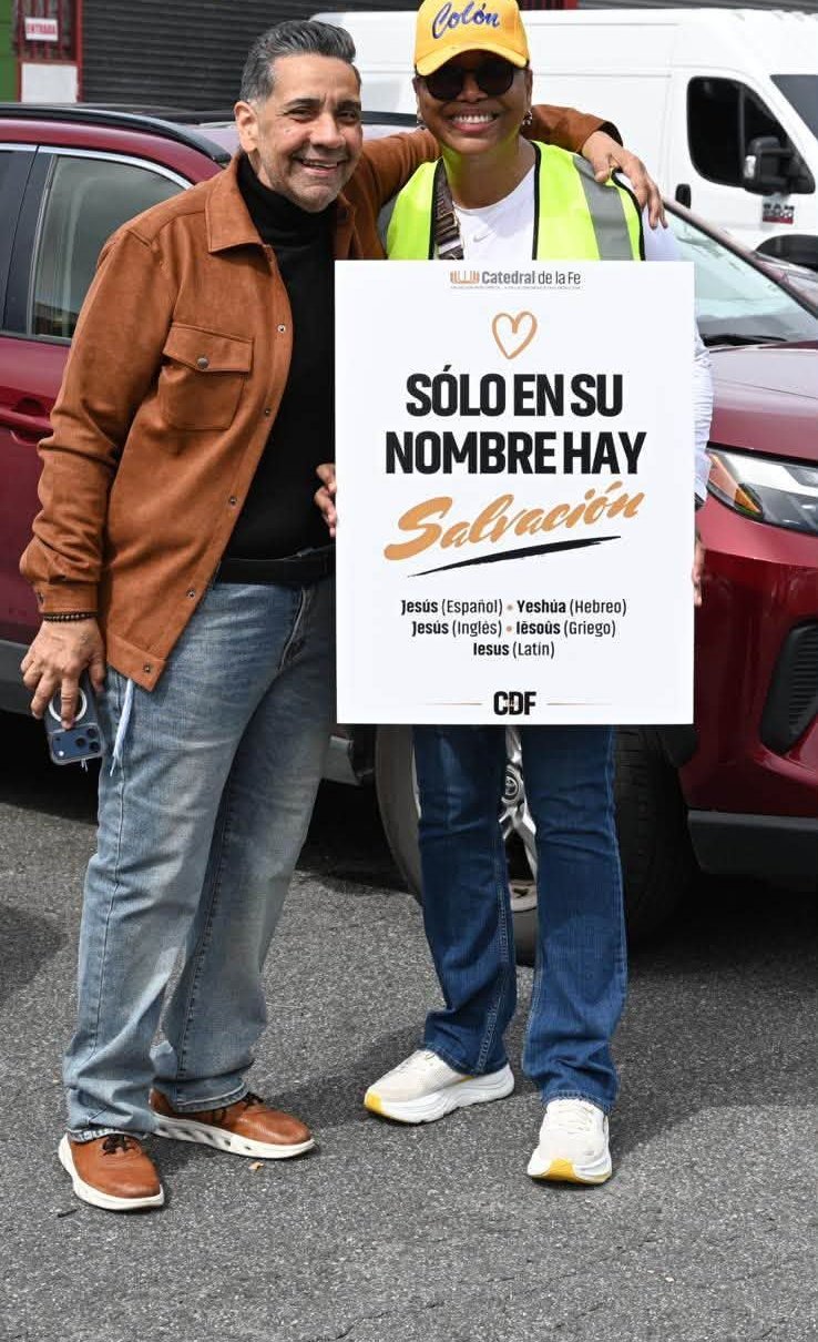 Voluntaria con el Pastor Walter y el letrero Solo en Su nombre hay salvación
