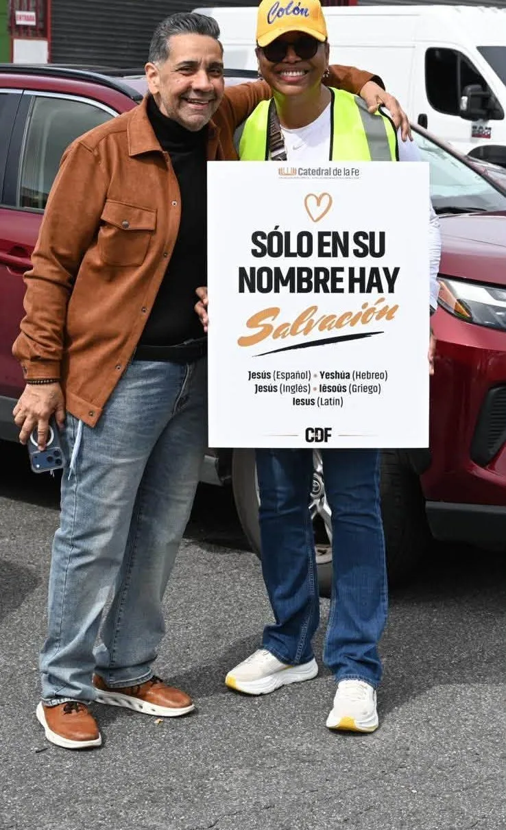 Voluntaria con el Pastor Walter y el letrero Solo en Su nombre hay salvación
